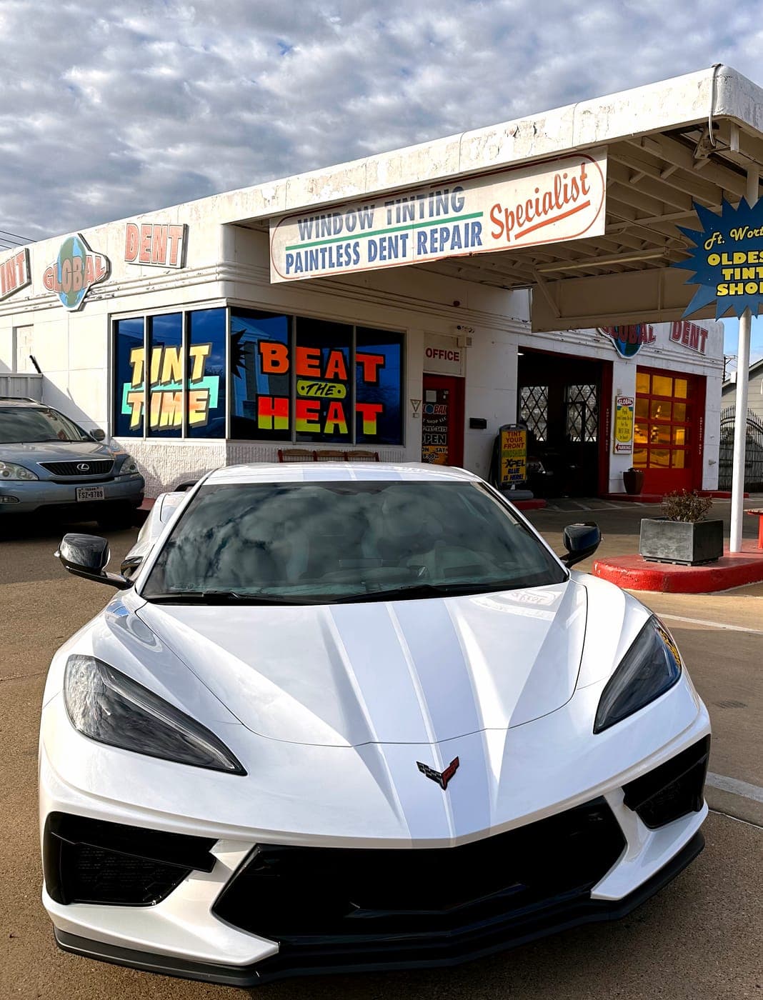White Corvette in front of the shop